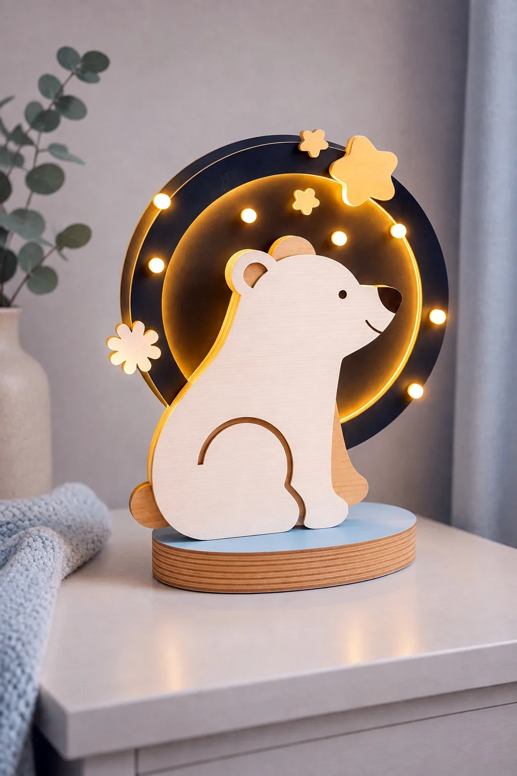 A wooden bear cub in front of a round panel ringed with small round light openings, free laser cut night light SVG from svgdiy.com