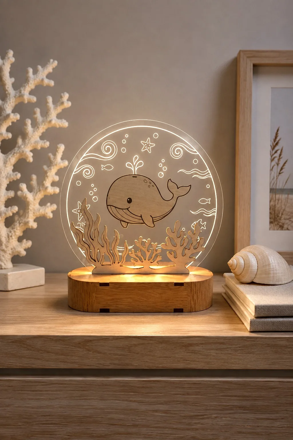 A wooden whale on a round acrylic panel with engraved swirls and starfish lit from the base, free laser cut night light SVG from svgdiy.com