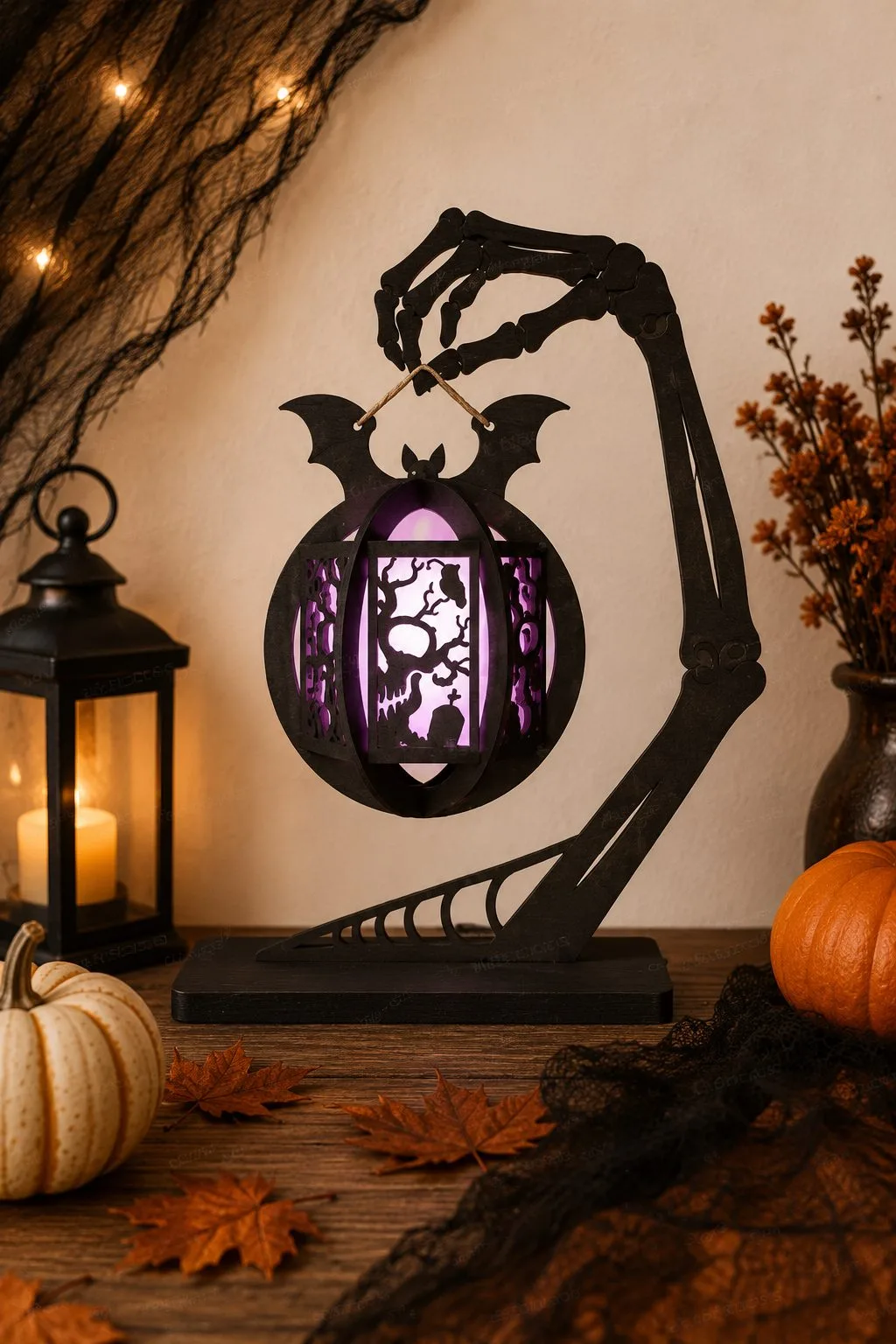 Skeleton hand stand holding a bat-winged lantern lit purple, spooky season laser cut SVG from svgdiy.com