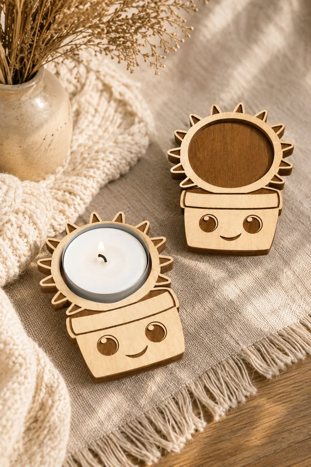 Flat wooden sun and flowerpot tealight holders with smiling faces beside a lit candle, free laser cut candle holder SVG from svgdiy.com