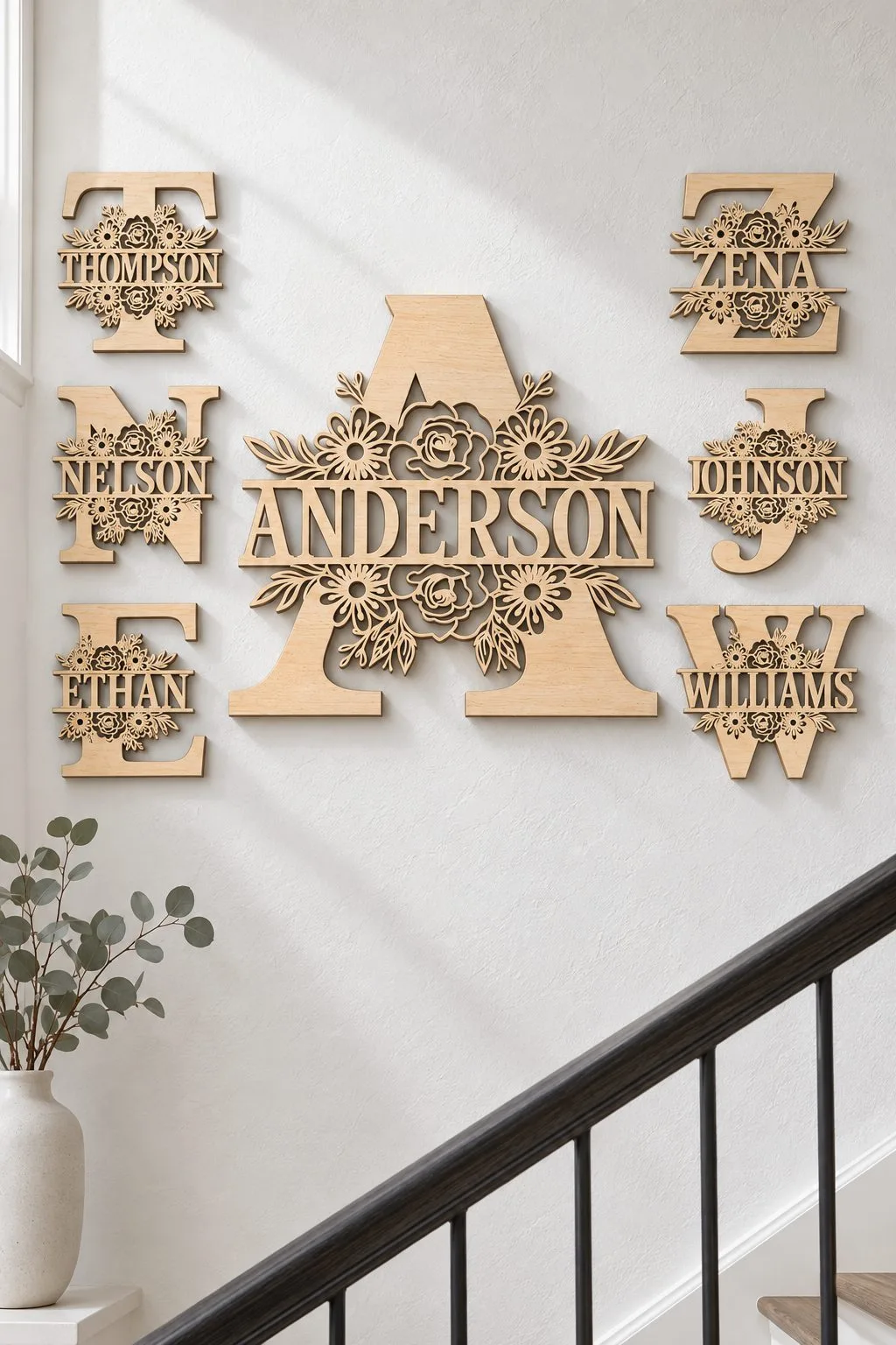 Split monogram letters with family names hung as a gallery on a staircase wall, free personalized laser cut SVG from svgdiy.com