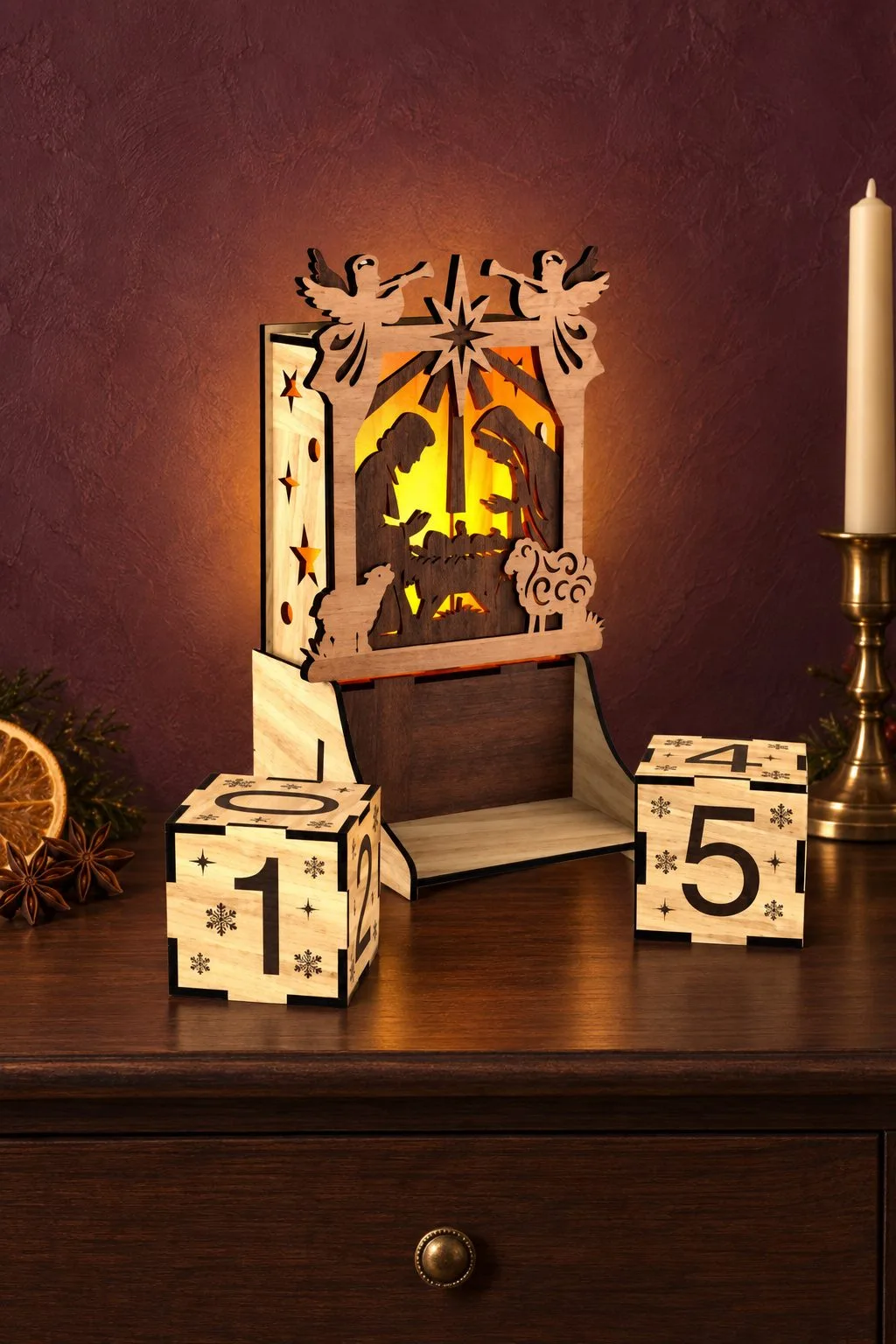 A laser cut nativity scene lantern lit from inside, with angels on top and two wooden countdown cubes showing the days, free laser cut SVG from svgdiy.com