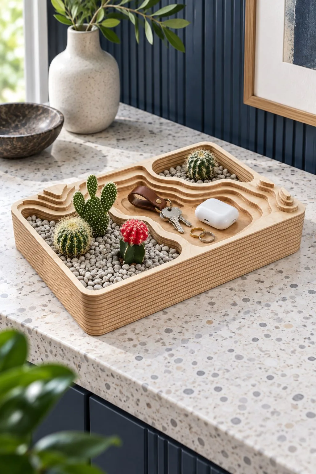 The topographic tray with small cacti and earbuds on a kitchen counter, free laser cut SVG from svgdiy.com